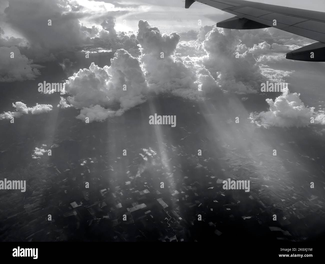 Vista aerea che vola sopra le nuvole e i raggi del sole drammatici e che piercing attraverso le nuvole, paesaggio di sole, luce solare, parte di aereo, ala, Foto Stock