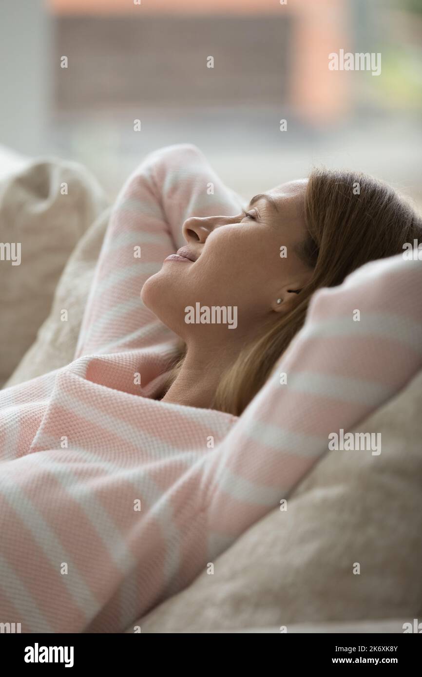 Donna attraente godere di relax, sdraiato su un comodo divano Foto Stock