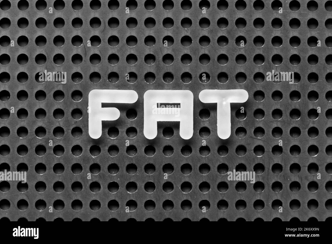 Lettera dell'alfabeto bianco in parola FAT (obesità o abbreviazione del test di accettazione in fabbrica, tabella di assegnazione dei file) su sfondo nero di pegboard Foto Stock