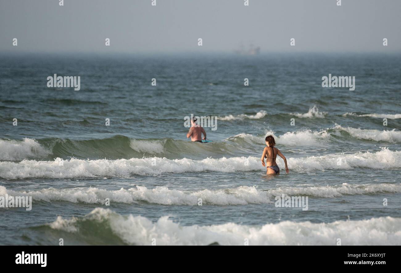 Mare mosso. Persone sulle onde in mare. Nuoto in mare con grandi onde. Condizioni pericolose in acqua. Foto Stock