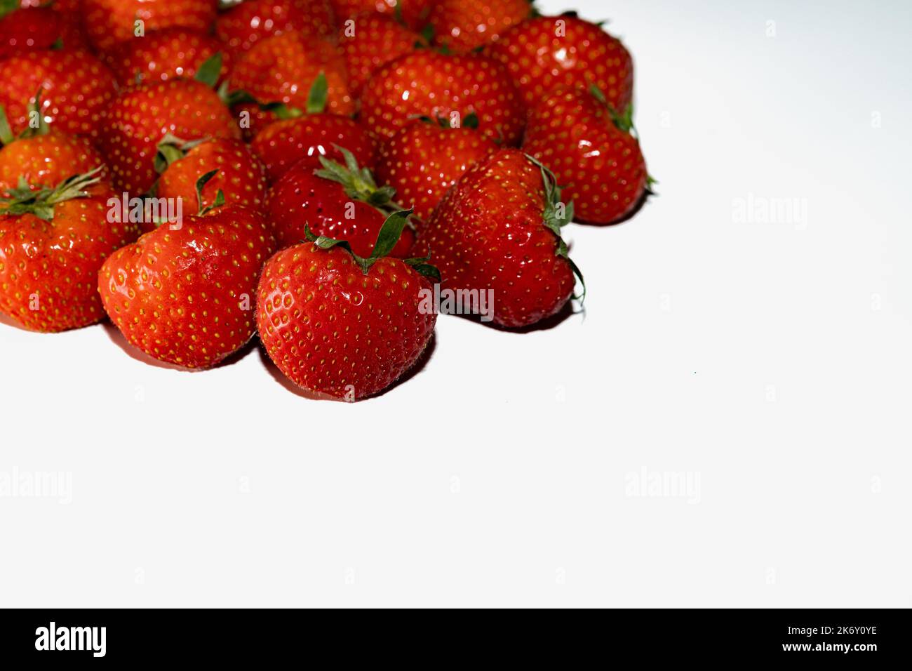 Fresche fragole rosse su fondo bianco Foto Stock