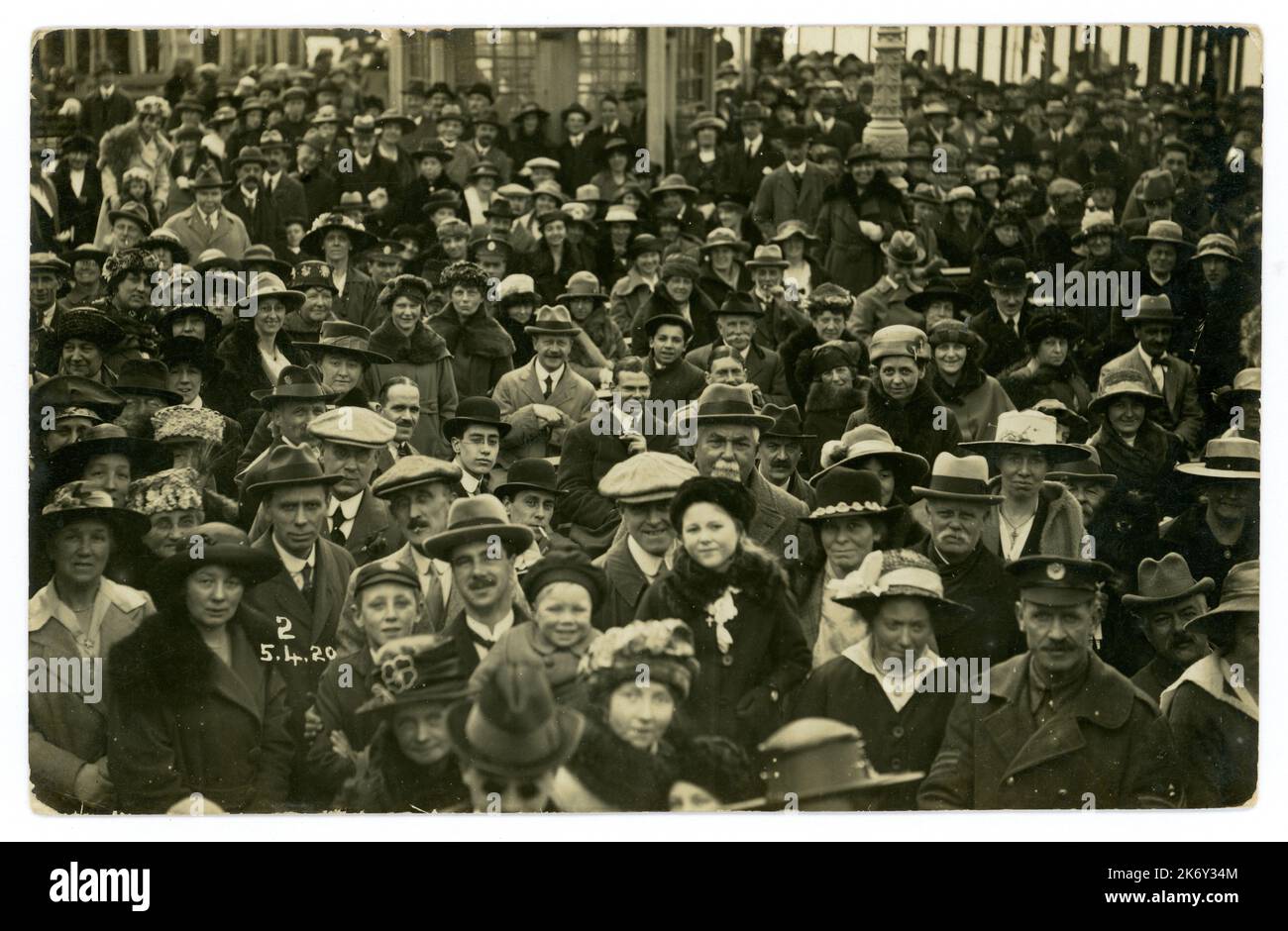 La folla originaria delle vacanze della classe operaia degli anni '1920 risale al 5 aprile 1920, località balneare britannica, con molti personaggi e mode, tra cui cappellini piatti e cappelli homburg. Foto retro del mare del Regno Unito. Foto Stock
