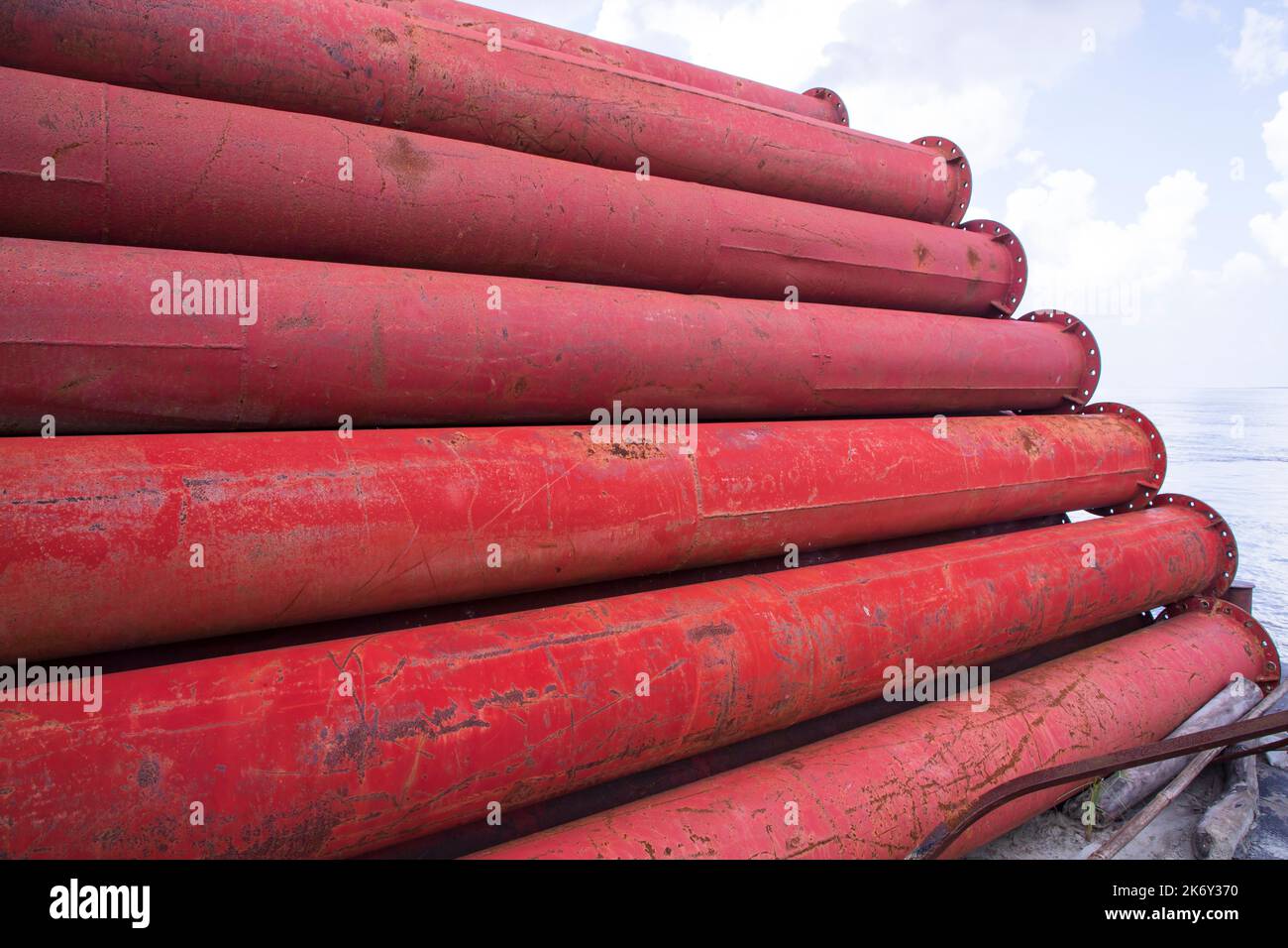 I tubi metallici in acciaio arrugginito impilano un campo industriale Foto Stock