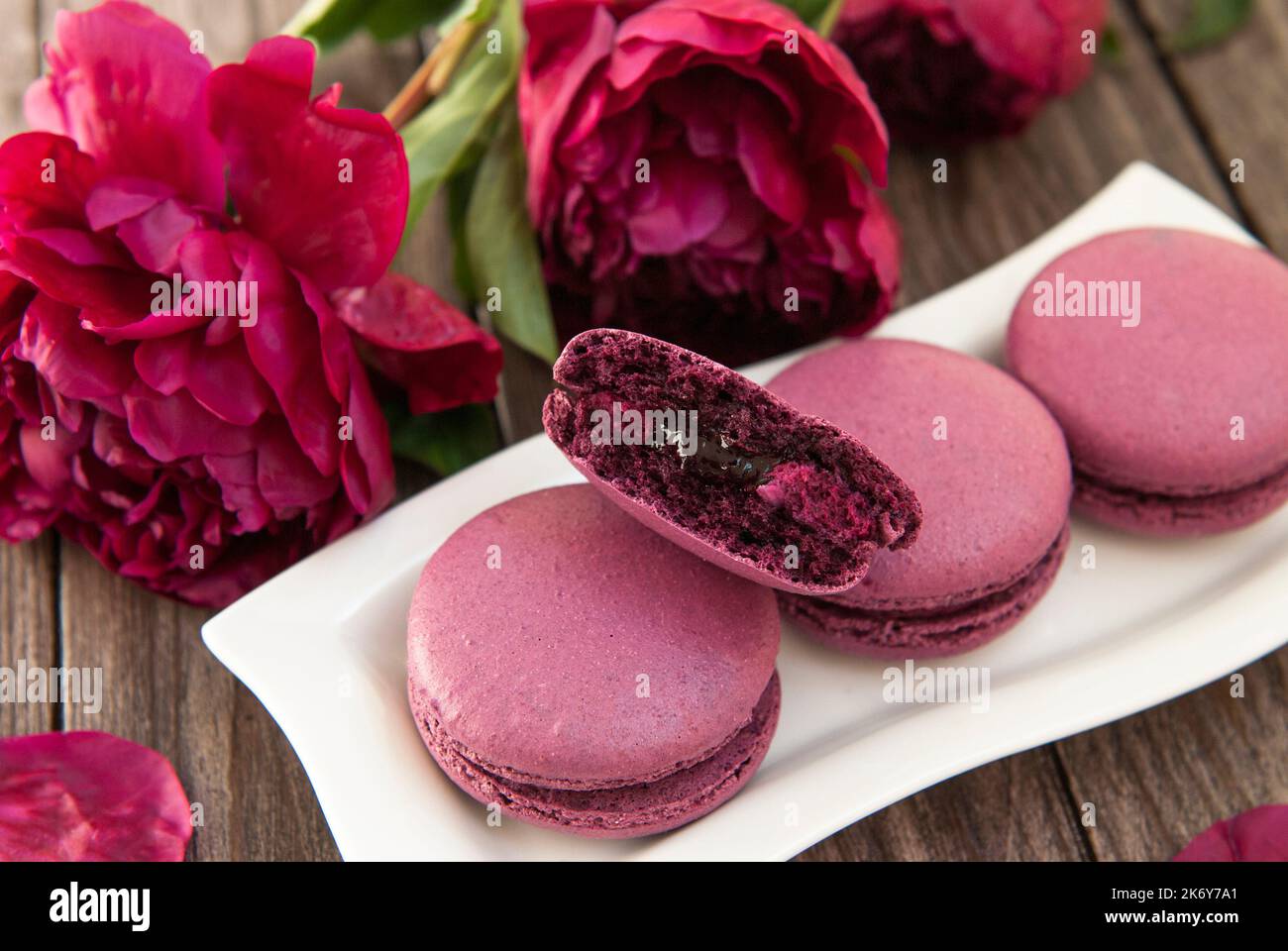 Amaretti ripieni di ribes, peonie viola su sfondo di legno Foto Stock