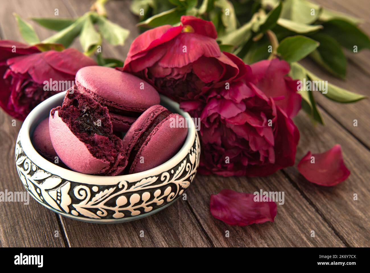 Amaretti ripieni di ribes, peonie viola su sfondo di legno Foto Stock