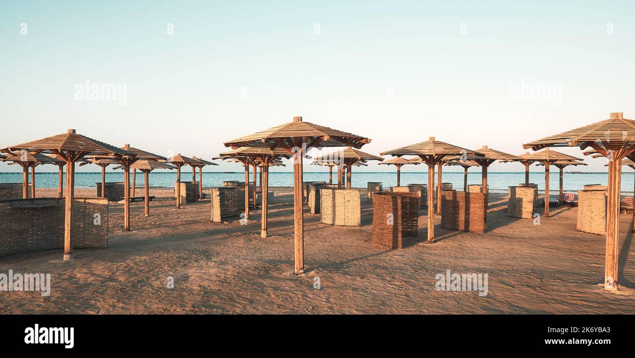 Ombrelloni e parabrezza in legno sulla spiaggia, tonificanti. Foto Stock