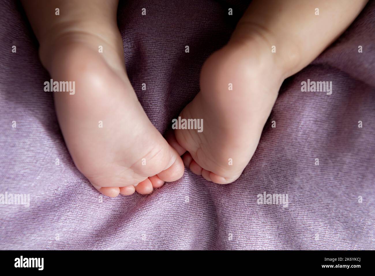 Una coperta di cashmere rosa dei piedi piccoli dei bambini piccoli Foto Stock