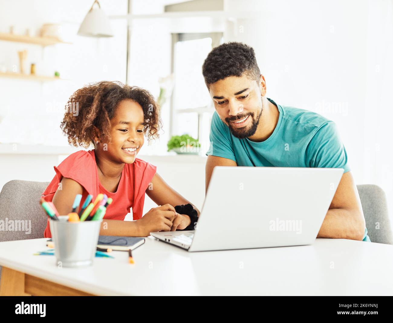 computer portatile computer istruzione padre figli figlia ragazza famiglia infanzia casa bambino genitore compiti classe attività Foto Stock