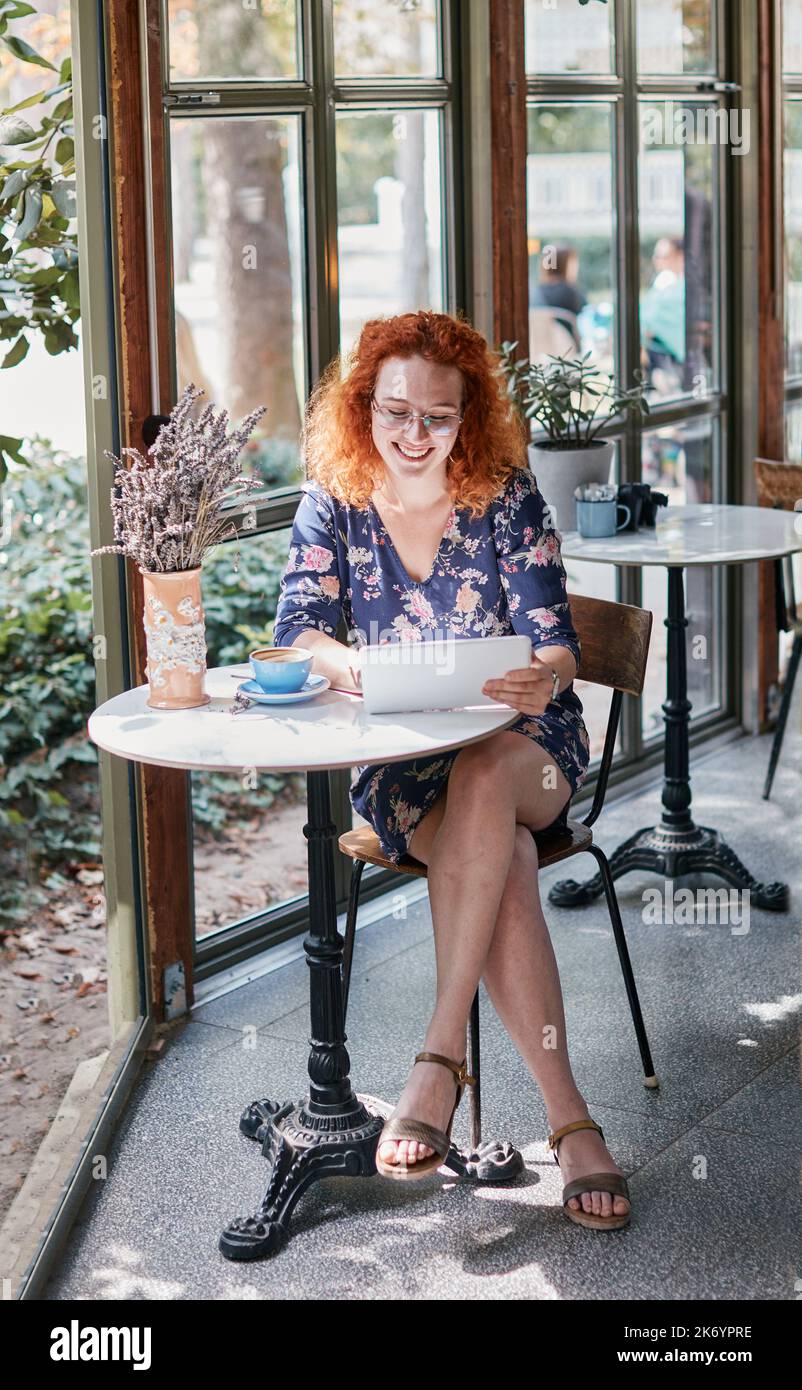 cafe donna ragazza lifestyle bere caffè giovane tablet computer utilizzando bella tazza sorridente felice femmina Foto Stock