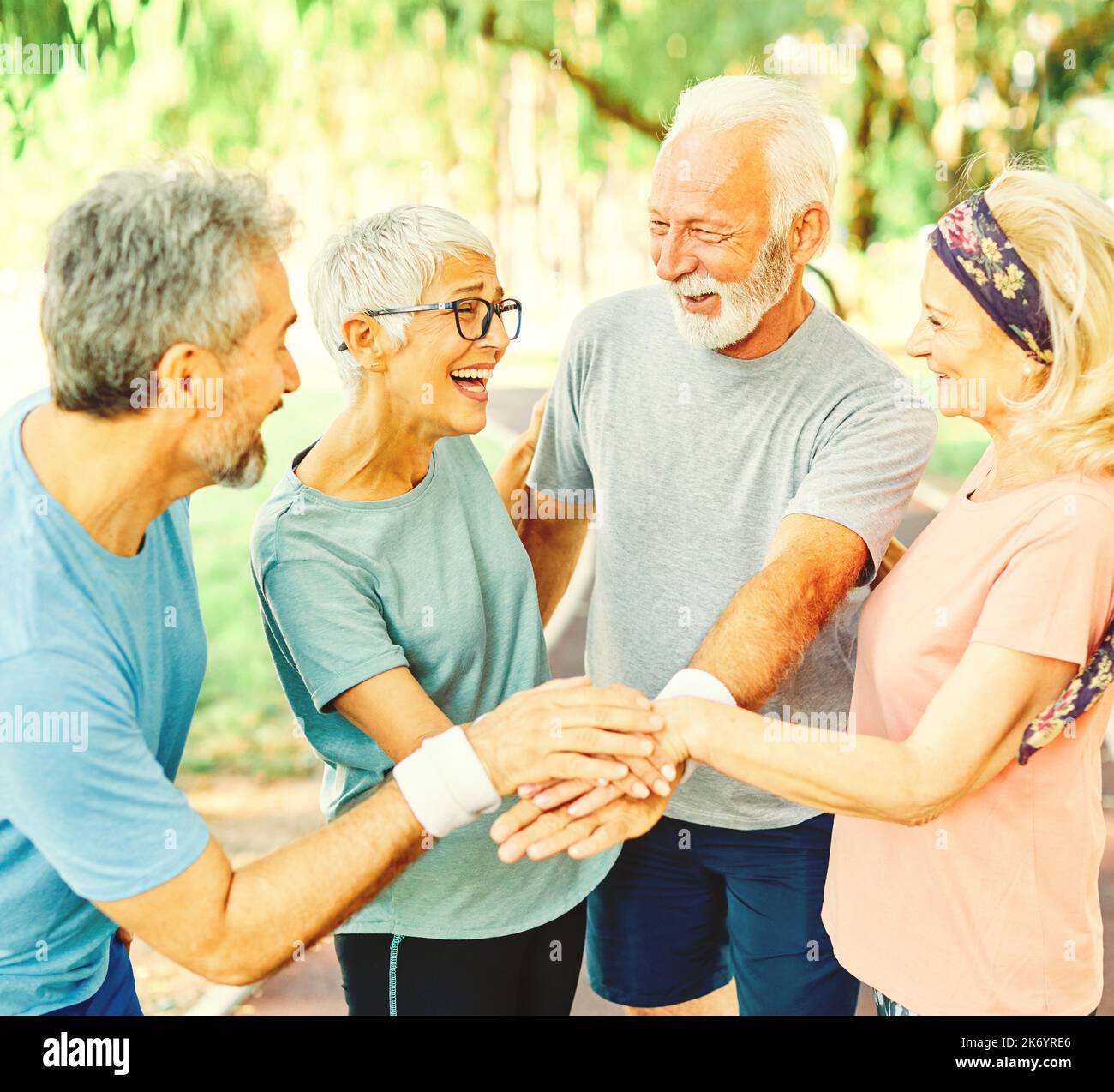 outdoor senior fitness donna uomo stile di vita sport attivo esercizio sano fitness pensione squadra insieme tenendo le mani Foto Stock