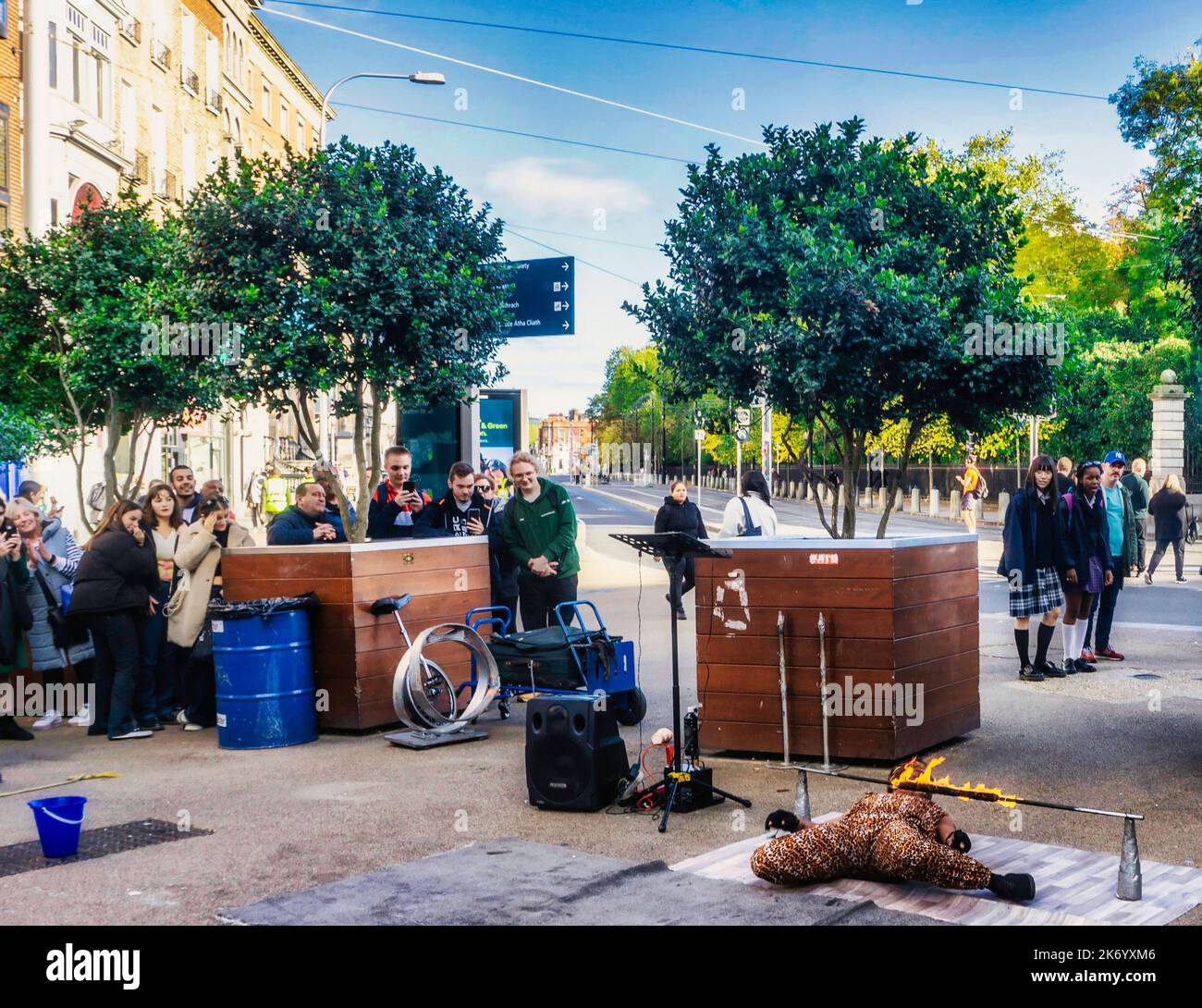 Un esecutore di strada del fuoco che risente la vita e l'arto, all'orrore degli onlookers su St Stephens Green, Dublino, Irlanda. Foto Stock