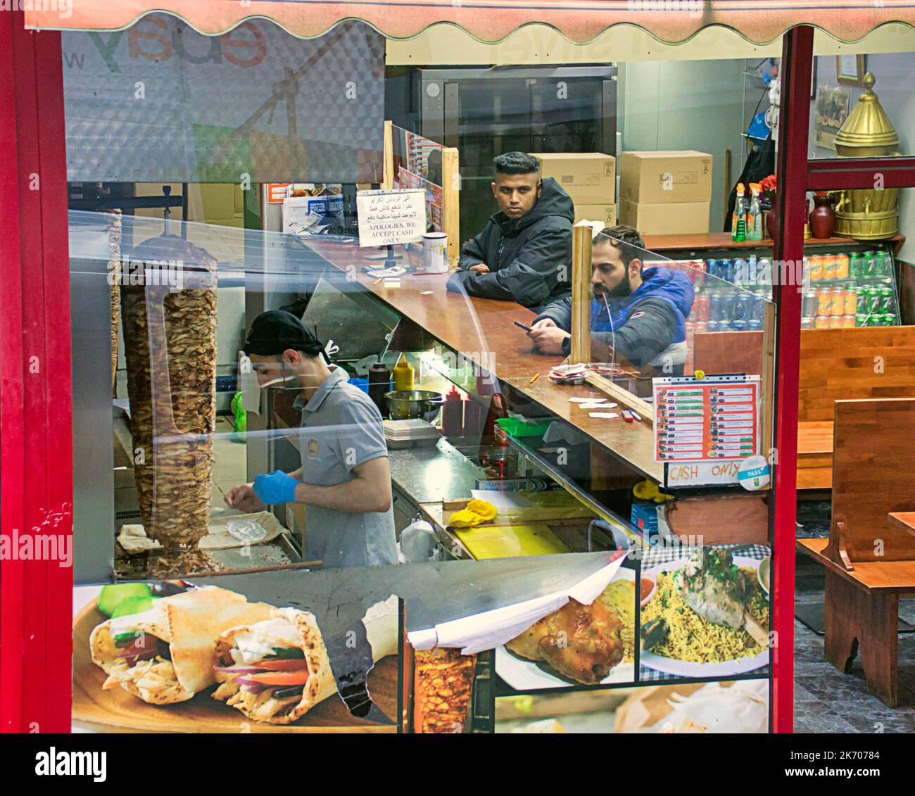 all'interno del kebab pizza take away fast food locale vista da una strada pubblica attraverso la finestra Foto Stock