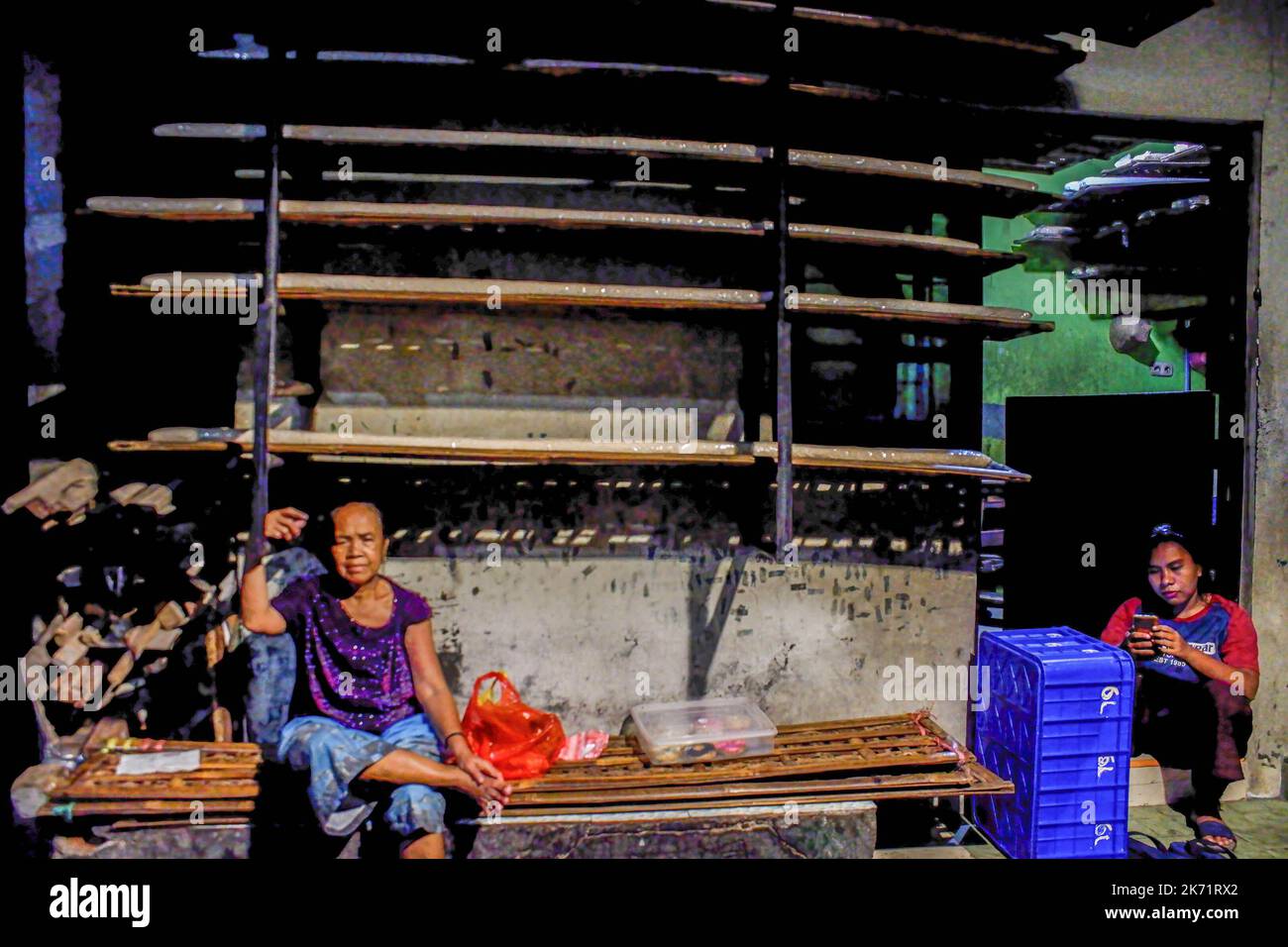 Giacarta, Indonesia. 16th Ott 2022. Un residente visto seduto di fronte a una casa nella zona di Johar Baru, Giacarta. Uno degli insediamenti più densamente popolati nel sud-est asiatico è nel distretto di Johar Baru, Jakarta, Indonesia. Sulla base dei dati dell'Agenzia Centrale di Statistica nel 2021, la densità di popolazione nel distretto è aumentata a 60.788 persone per chilometro quadrato, rendendo la regione una delle aree più densamente popolate del Sud-Est asiatico. (Foto di Faisal Ramadhan/SOPA Images/Sipa USA) Credit: Sipa USA/Alamy Live News Foto Stock