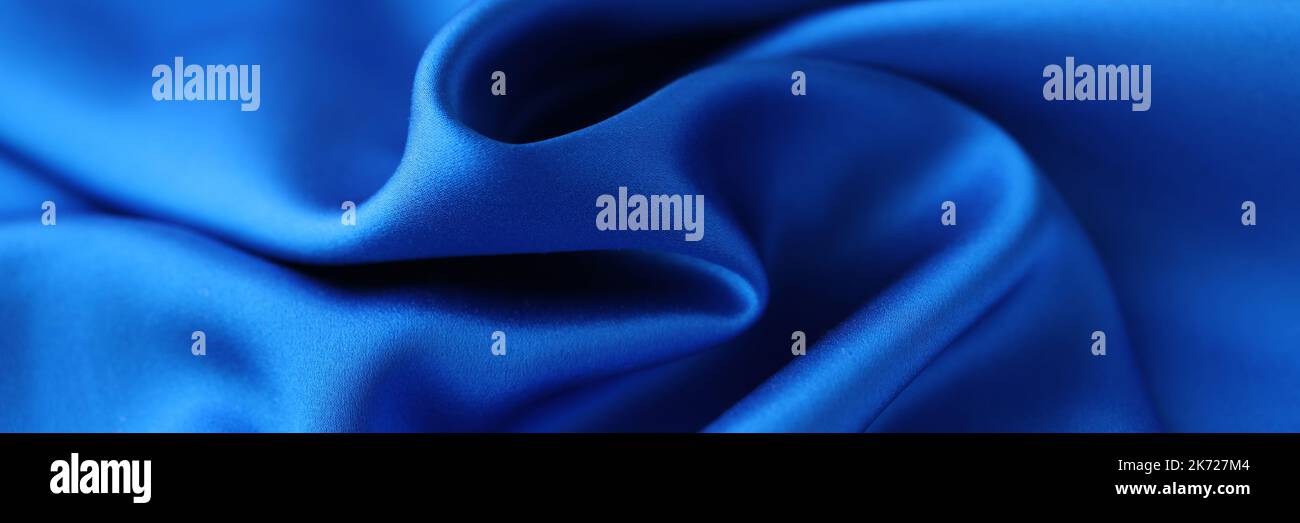 Primo piano in tessuto satinato blu. Tessuto naturale o satinato poliestere Foto Stock
