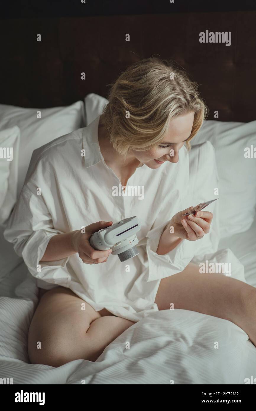 Donna bionda che fotografa in camera da letto Foto Stock