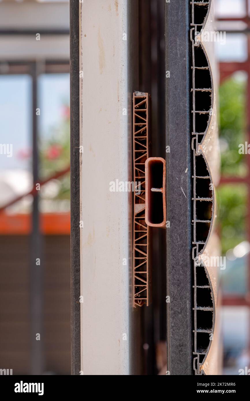 Rivestimento di facciata avvitato in un profilo di ferro per coprire l'esterno di un edificio Foto Stock