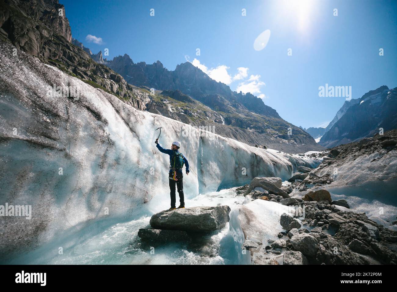 Uomo con pickax esplorando le montagne in inverno Foto Stock
