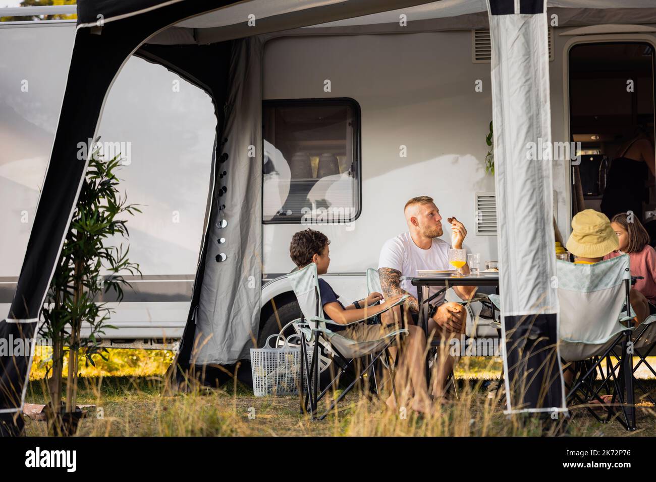 Relax in famiglia di fronte al camper trailer Foto Stock
