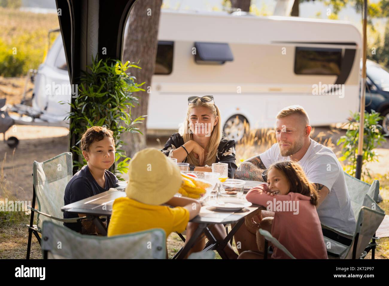 Famiglia seduti al tavolo da picnic Foto Stock