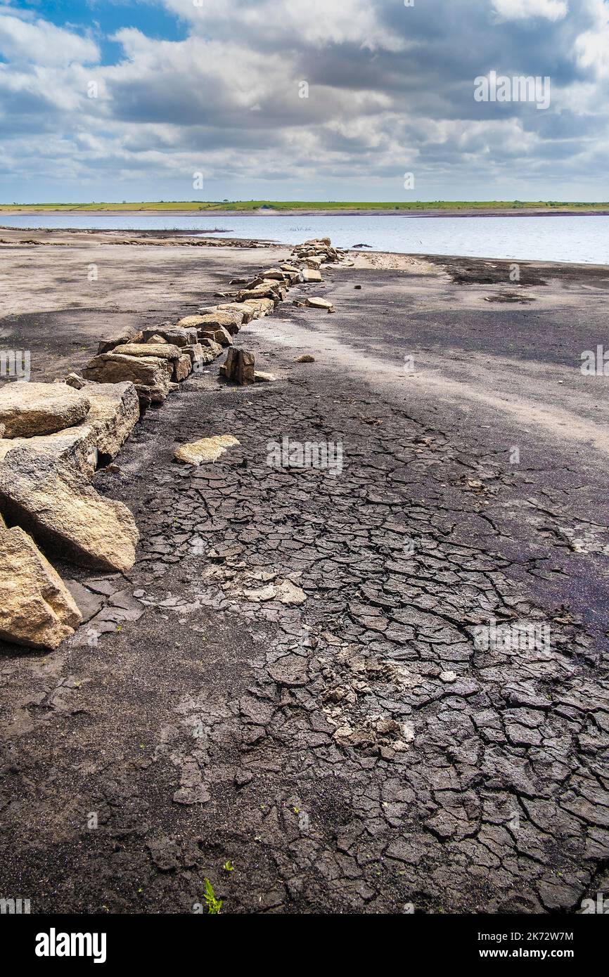 I resti di una vecchia Cornish Hedge muro esposto dalla caduta dei livelli di acqua causata da condizioni di siccità gravi al lago Colliford serbatoio su Bodmin Moo Foto Stock