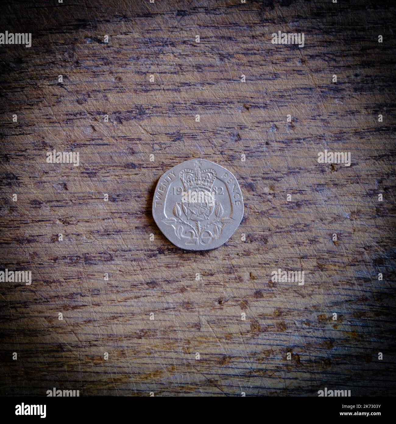 moneta da venti pence isolata su sfondo di legno Foto Stock