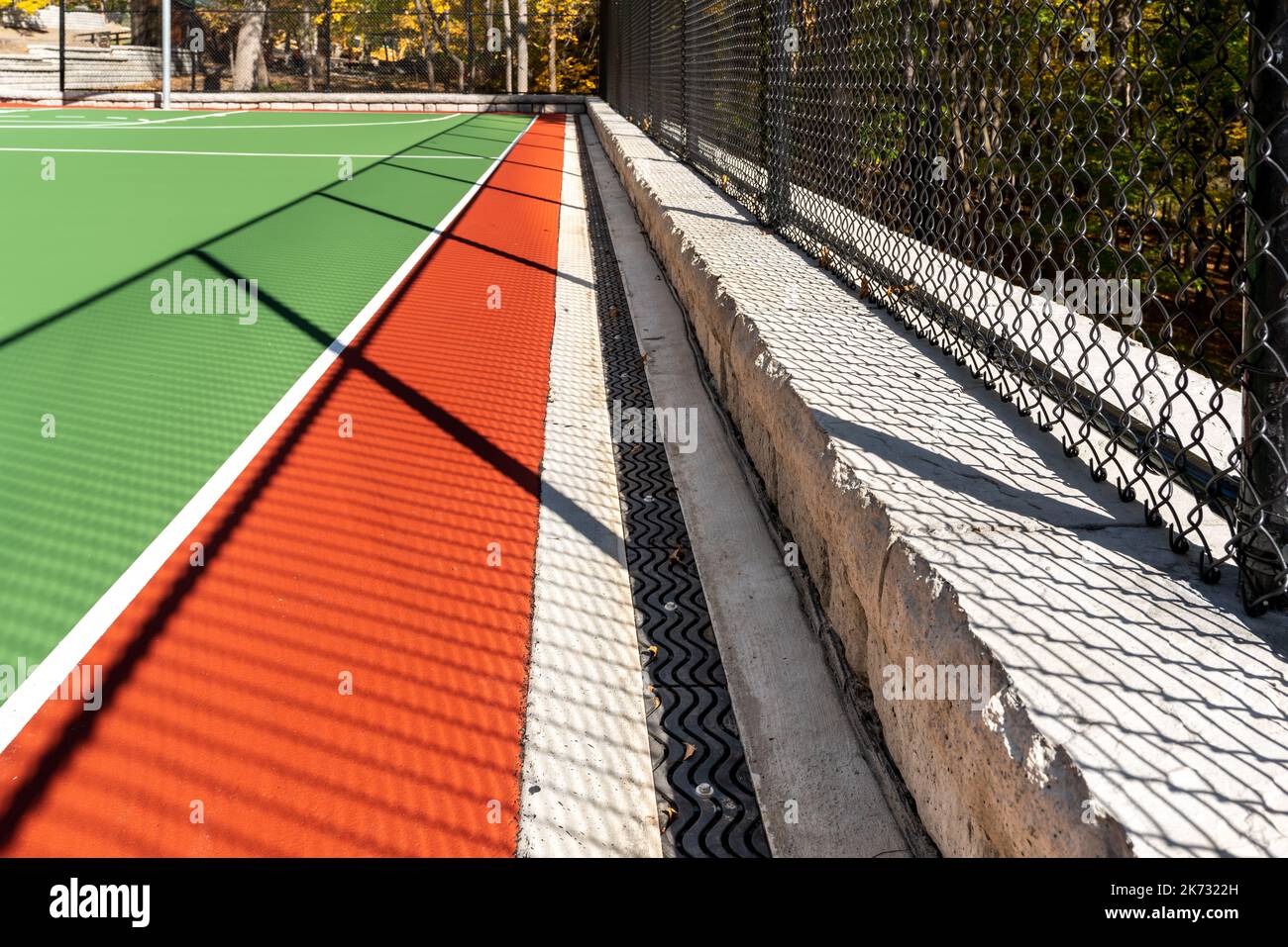Trincea drain lungo il campo da pallacanestro all'aperto presso il parco giochi della scuola. Foto Stock