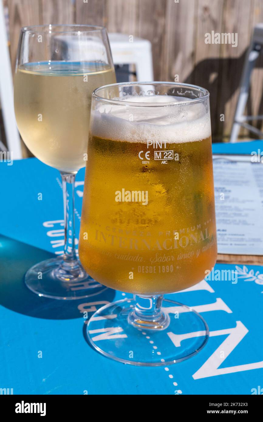 Bevande. Un bicchiere di vino bianco e una pinta di birra lager Foto stock  - Alamy