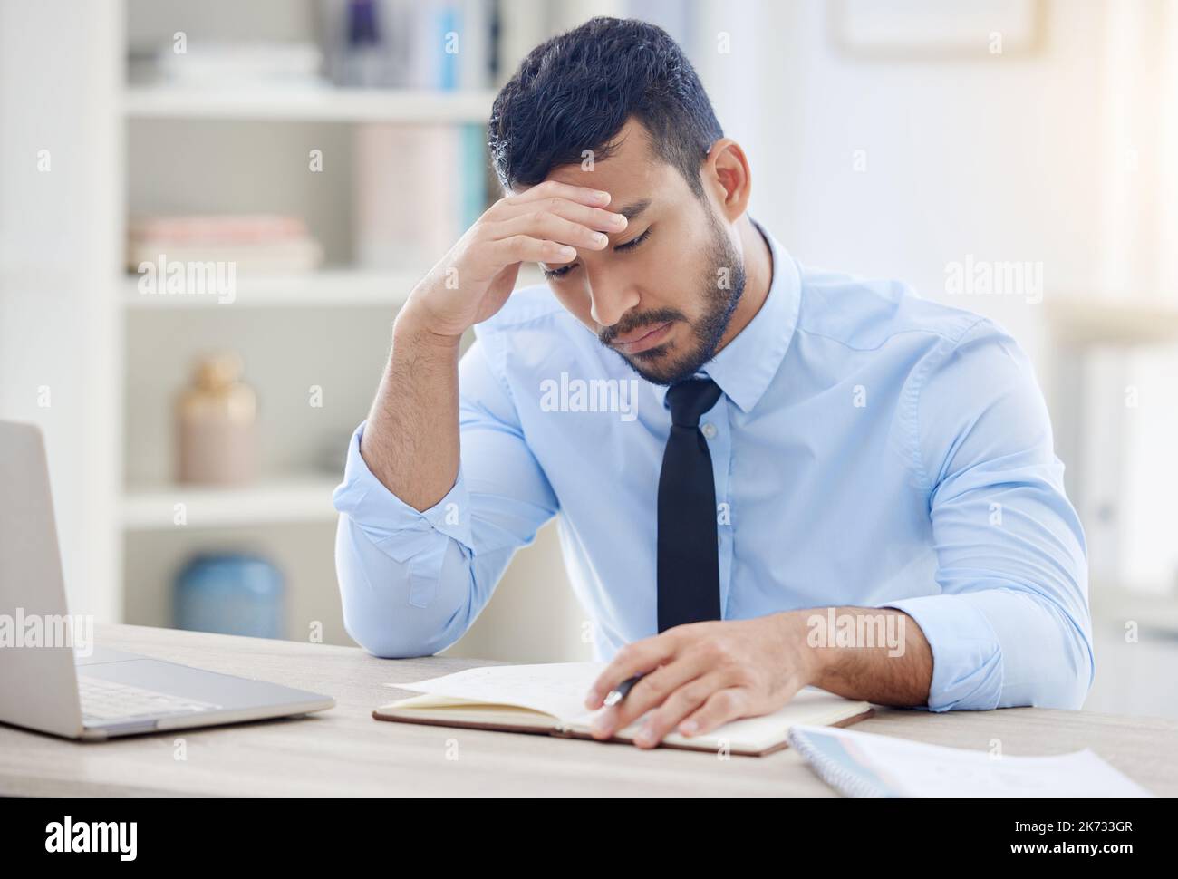 Devo andare via adesso. un giovane uomo d'affari che vive un mal di testa sul lavoro. Foto Stock