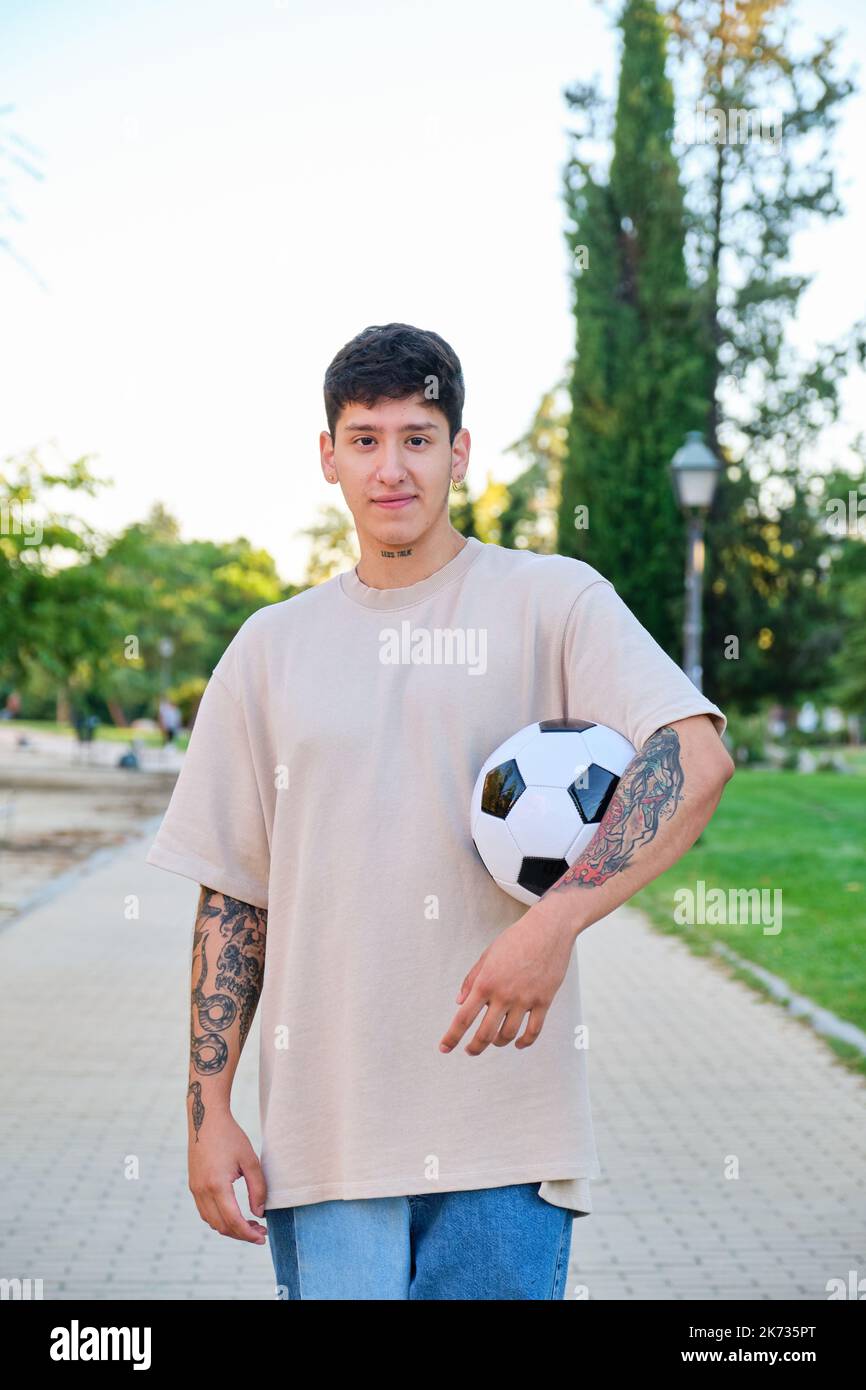 Un ecuadoriano che si posa con una palla da calcio e sorride per strada. Foto Stock