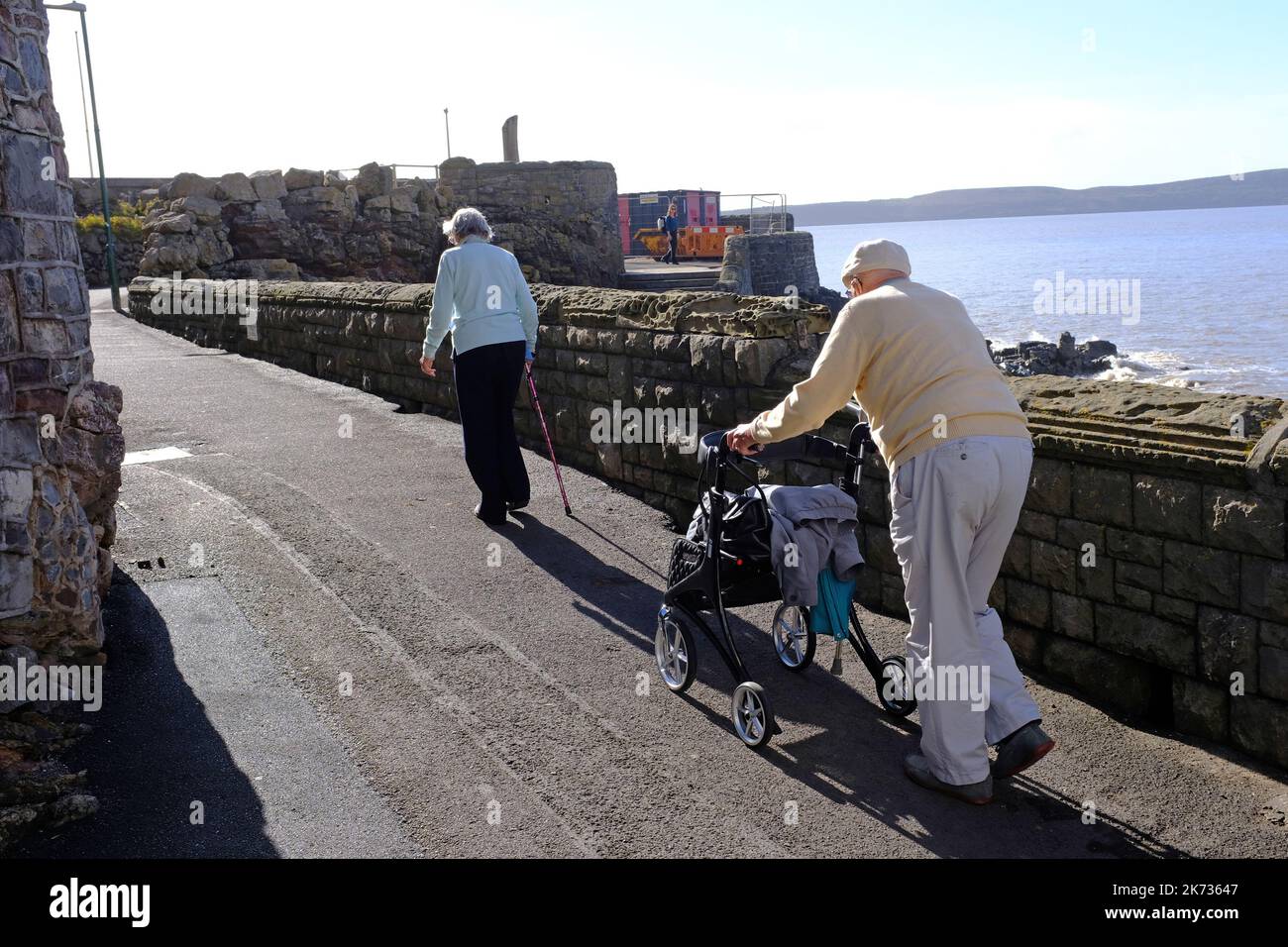 Due anziani pensionati che camminano su un pendio a Weston Super Mare Foto Stock