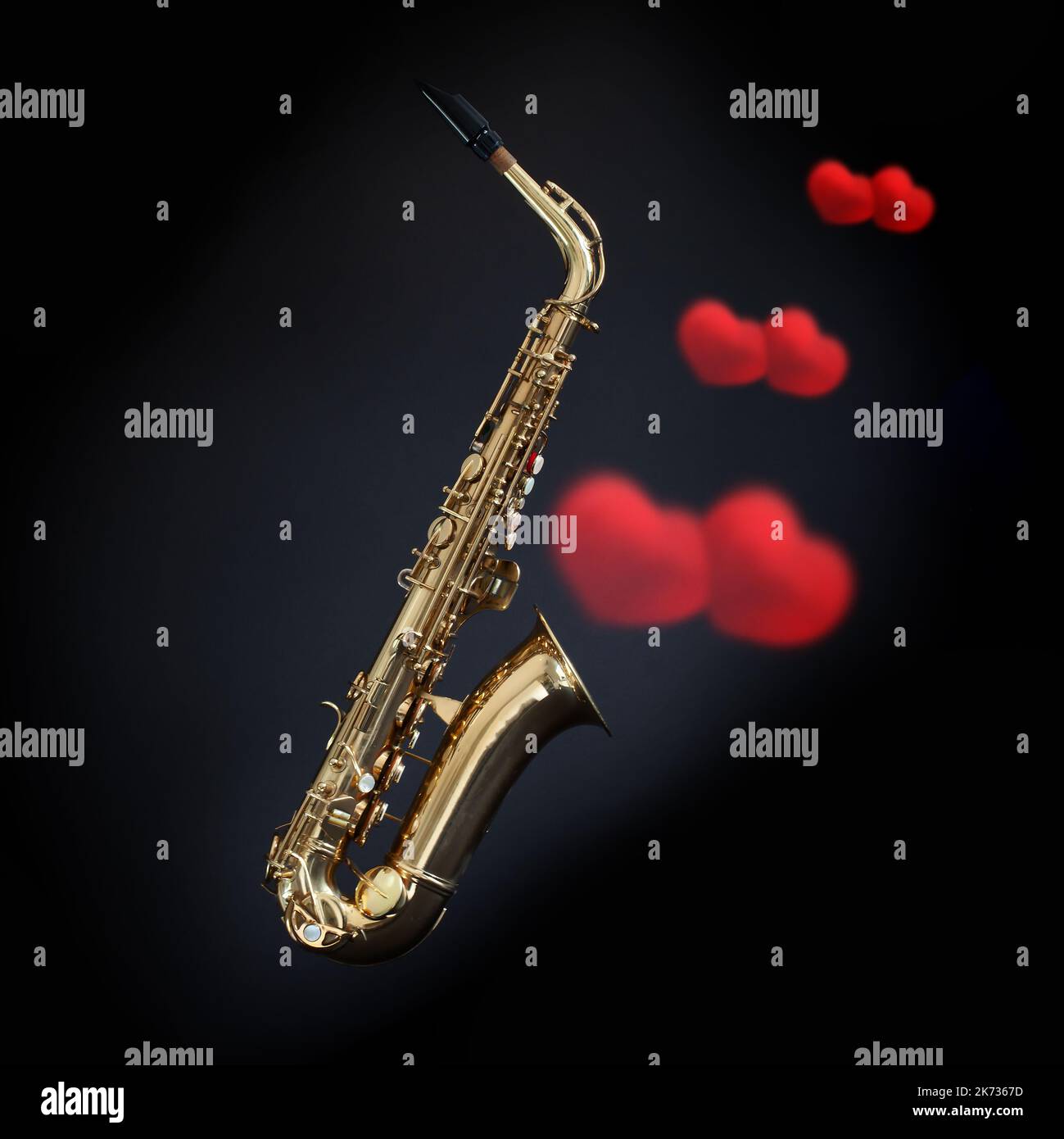 Sassofono con cuori d'amore rossi che escono dalla campana su sfondo nero. Concetto romantico di musica in ottone Foto Stock