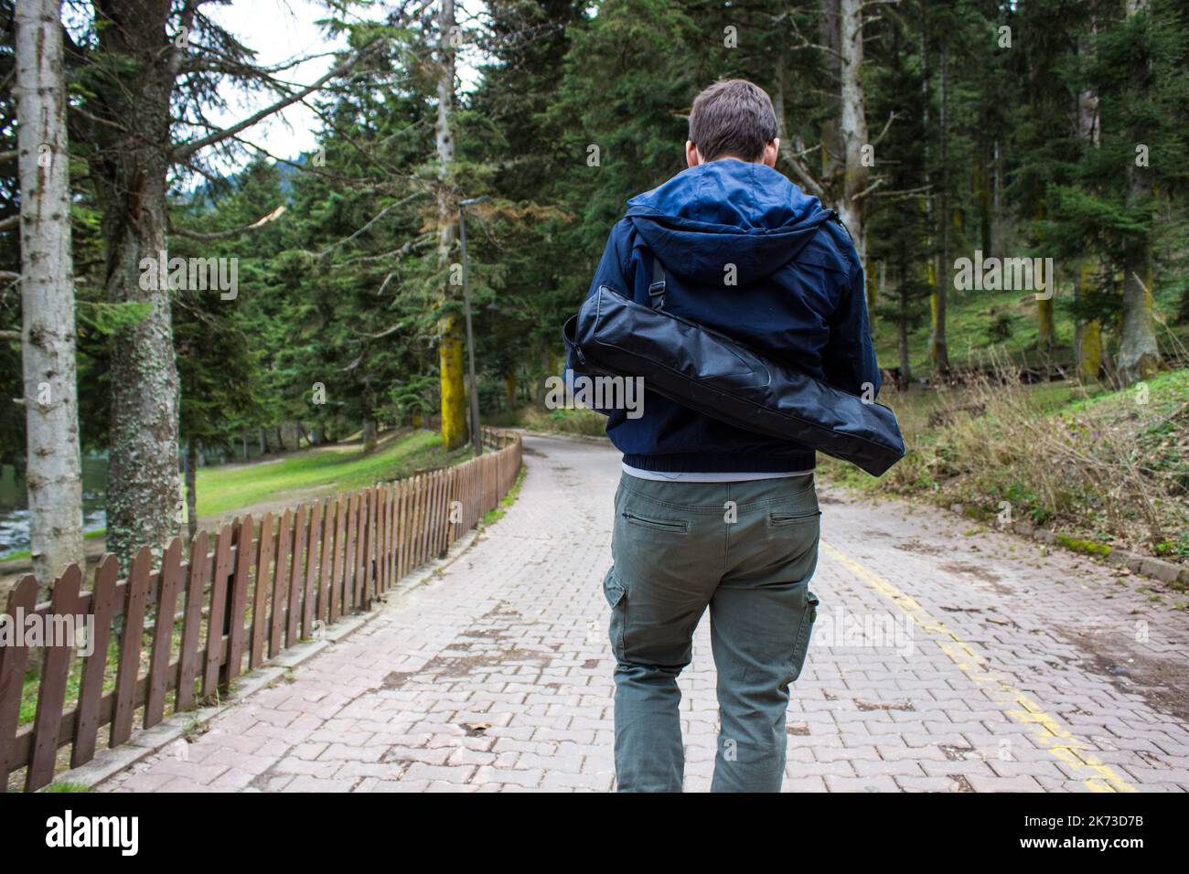 Giovane escursionista uomo escursioni in montagna durante la stagione autunnale. Giovane uomo escursionista con pantaloni cargo che trasportano la tenda sulla schiena e camminano nella foresta. Foto Stock