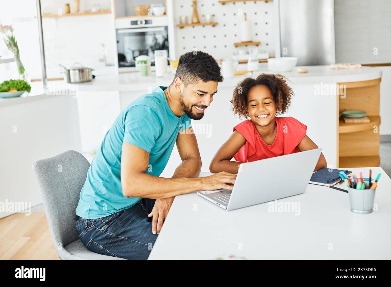 computer portatile computer istruzione padre figli figlia ragazza famiglia infanzia casa bambino genitore compiti classe attività Foto Stock