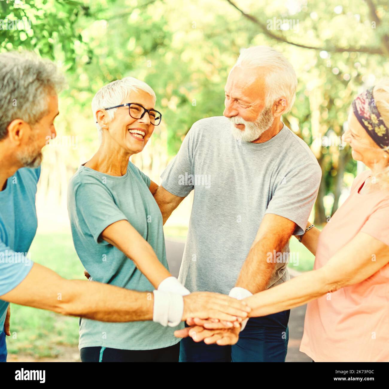 outdoor senior fitness donna uomo stile di vita sport attivo esercizio sano fitness pensione squadra insieme tenendo le mani Foto Stock
