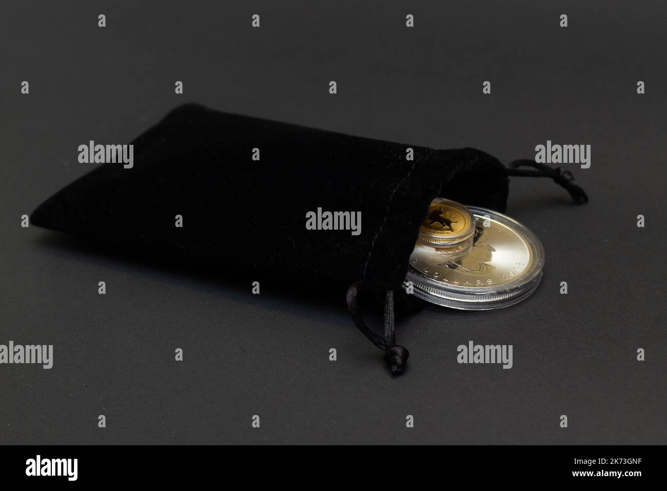 Helsingi, Finlandia - 16 agosto 2018: Monete d'oro di investimento del Bullion in borsa nera del regalo del velluto su fondo scuro. Foto Stock