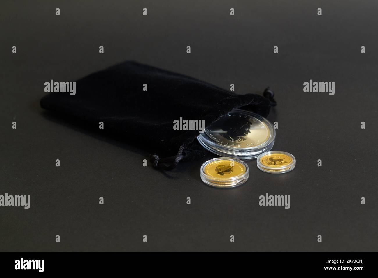 Helsingi, Finlandia - 16 agosto 2018: Monete d'oro di investimento del Bullion in borsa nera del regalo del velluto su fondo scuro. Foto Stock