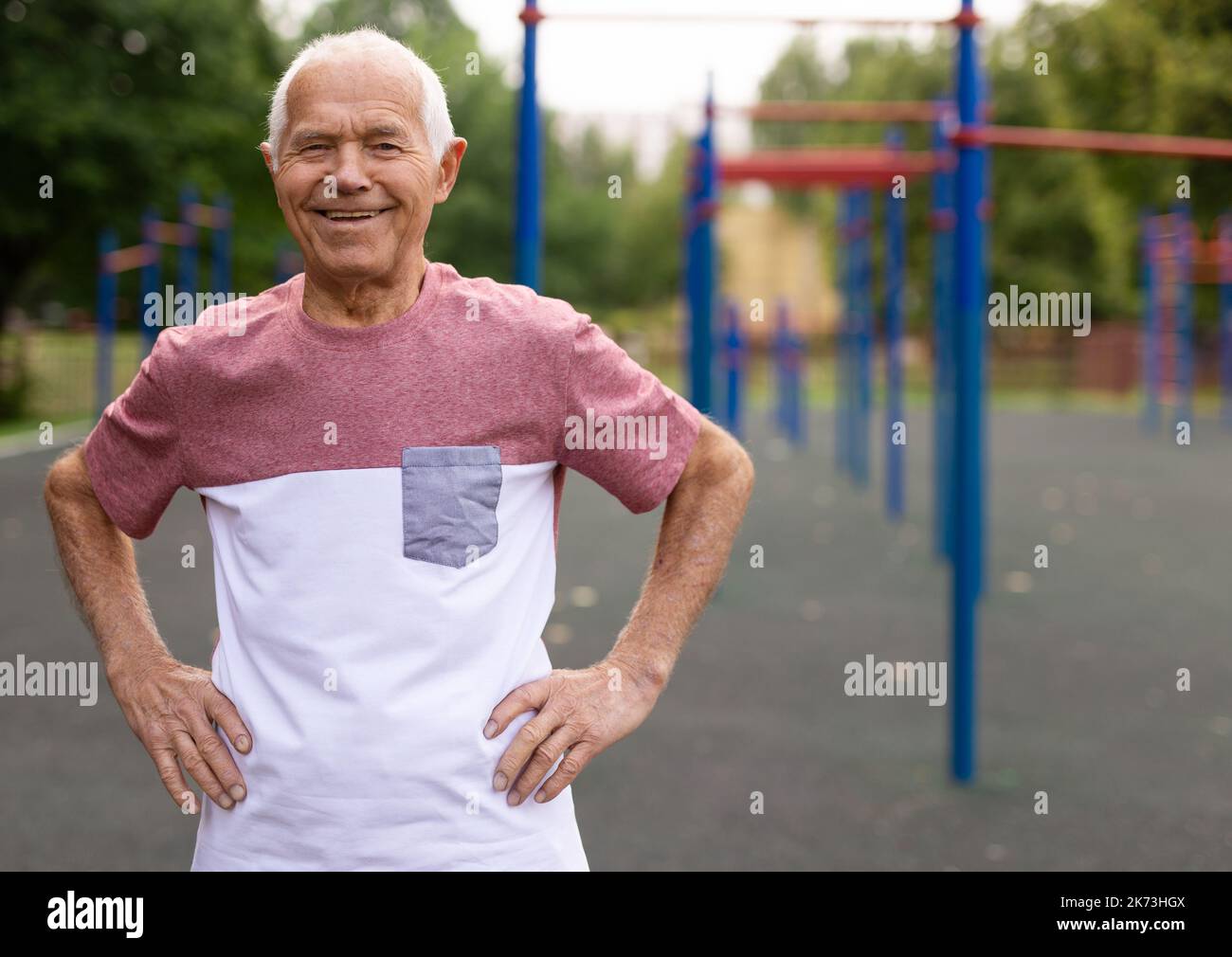 Ritratto di uomo anziano positivo in abbigliamento sportivo sul parco giochi Foto Stock