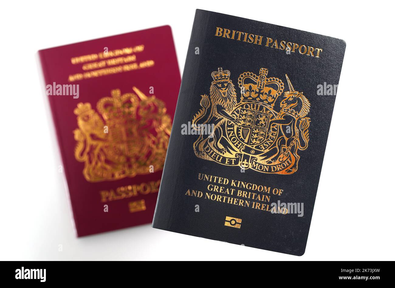 Un passaporto britannico blu britannico di fronte al passaporto europeo britannico su sfondo bianco. Foto Stock