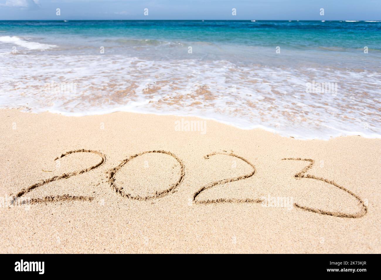 Capodanno 2023, scritta sulla spiaggia con onde Foto Stock