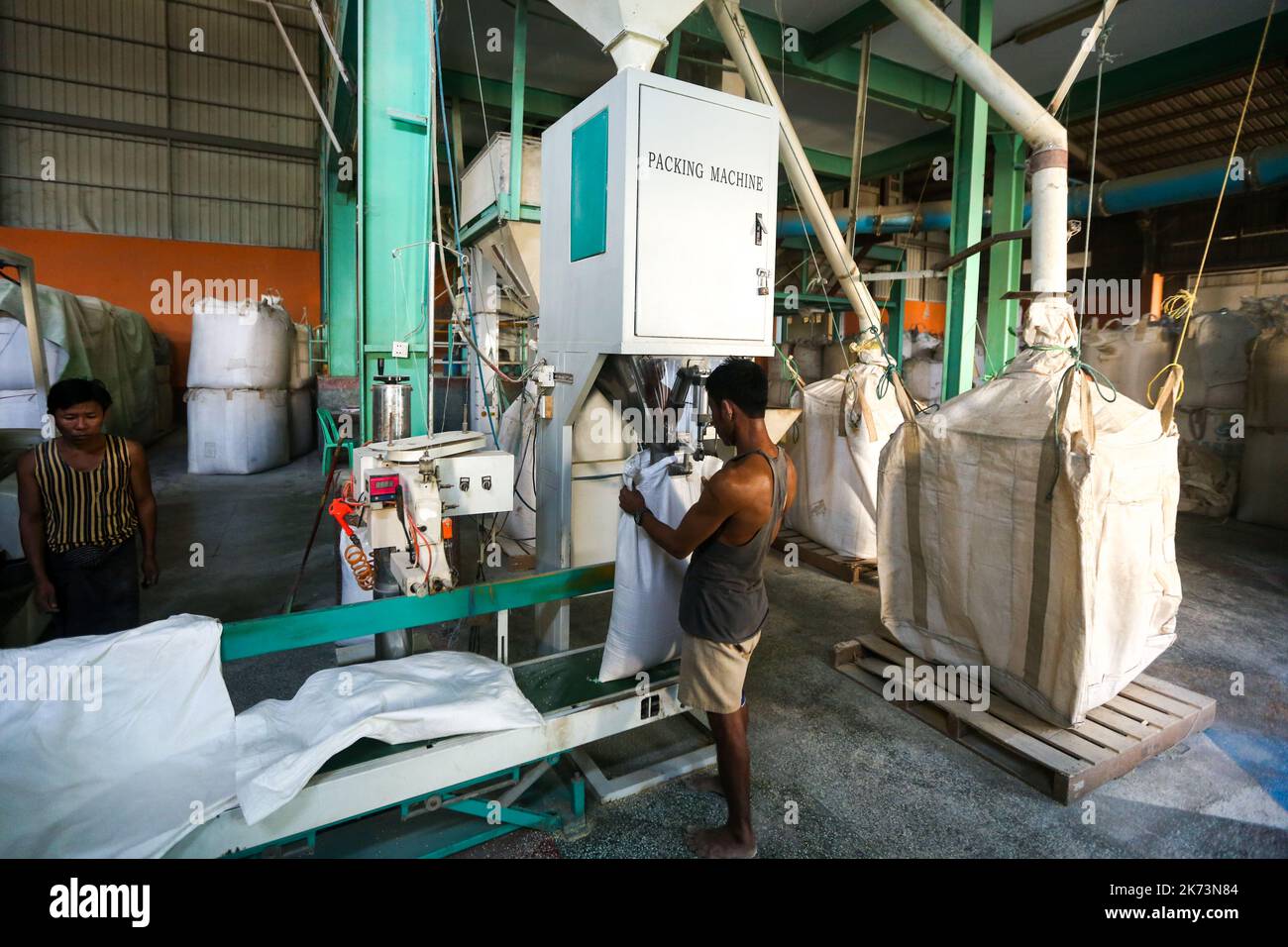 Yangon, Myanmar. 17th Ott 2022. Un lavoratore impacca fagioli con una macchina di imballaggio in un impianto di lavorazione fagioli e legumi a Yangon, Myanmar, 17 ottobre 2022. Myanmar ha esportato più di 811.812 tonnellate di fagioli e legumi per un valore di oltre 637 milioni di dollari USA nella prima metà dell'anno fiscale 2022-23, ha mostrato le cifre del Ministero del Commercio di Lunedi. Credit: MYO Kyaw Soe/Xinhua/Alamy Live News Foto Stock