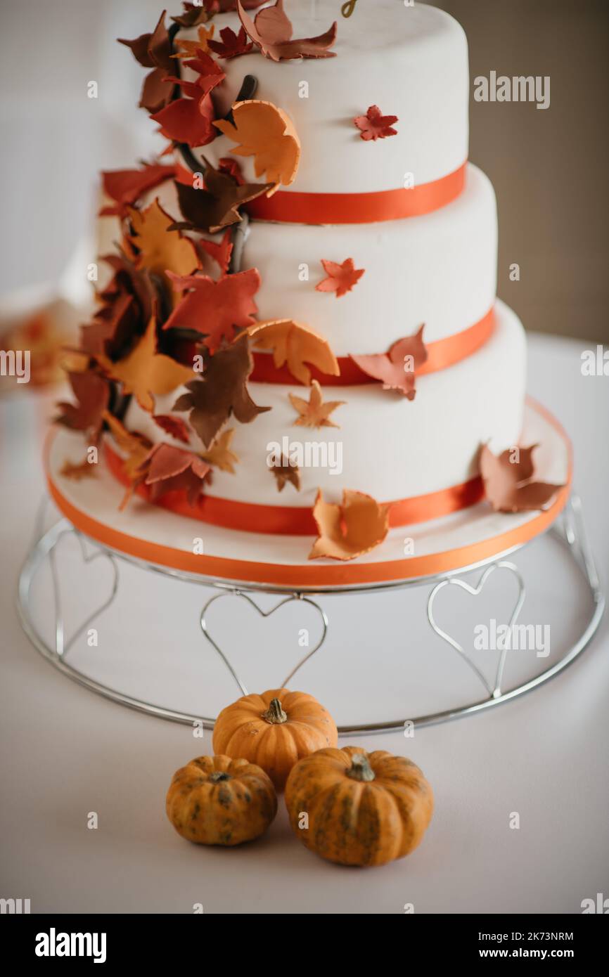Torta nuziale autunnale coperta di dolci foglie colorate autunnali Foto Stock