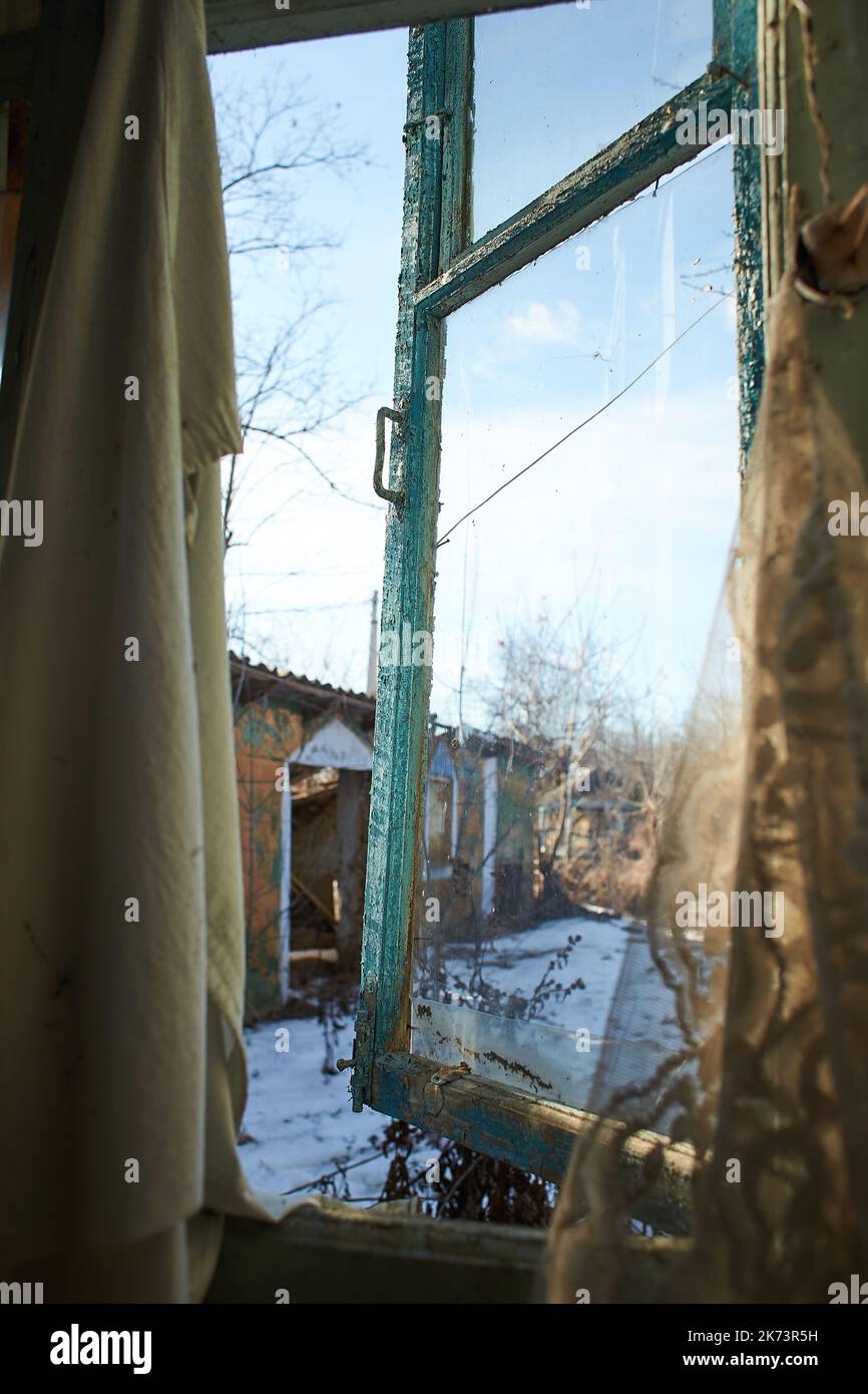 Vecchia finestra con tela di ciottoli in vecchio cortile abbandonato. Vista dall'interno Foto Stock