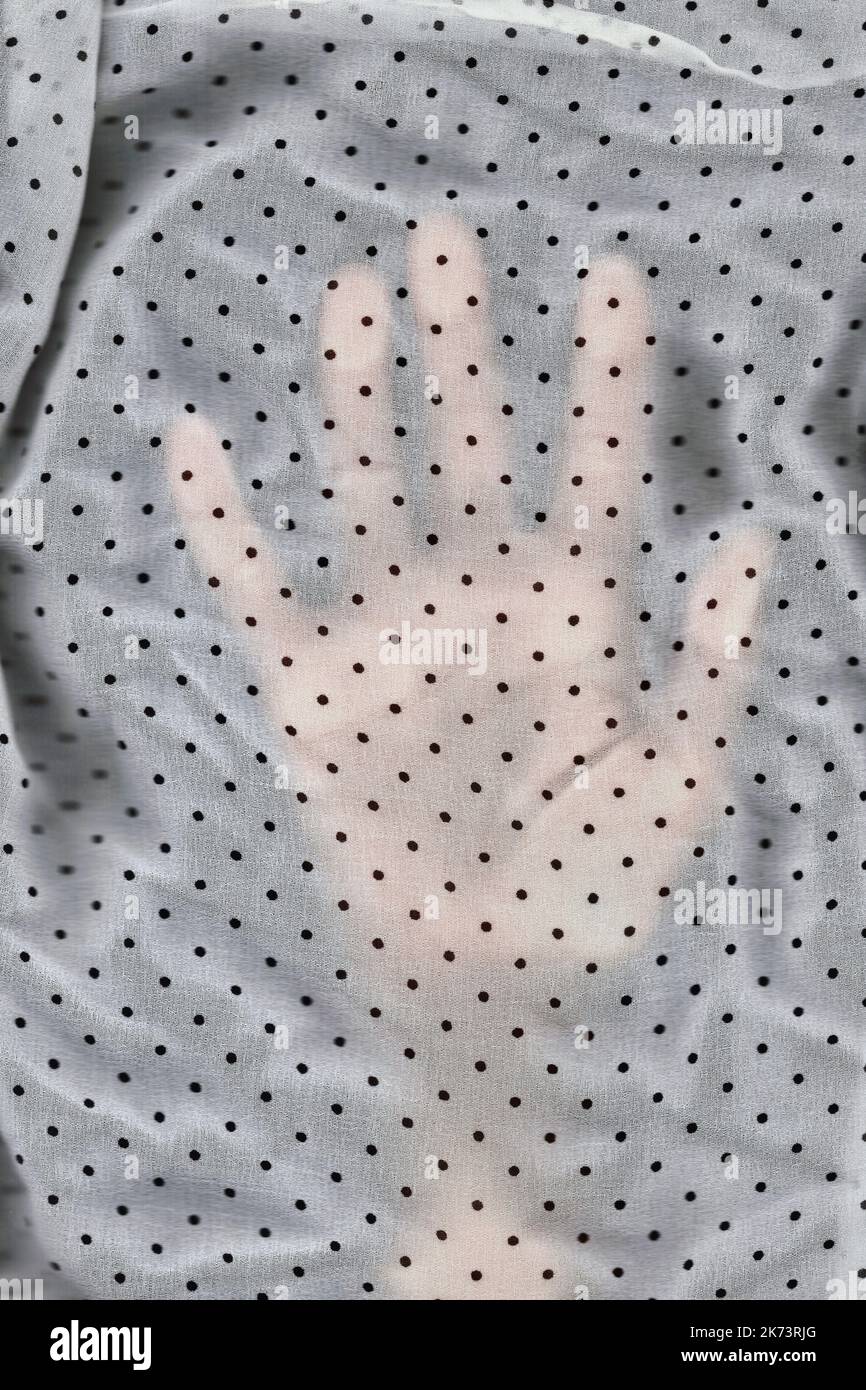Immagine dello scanner di una mano sotto il tessuto velato a pois di polka Foto Stock Immagine dello scanner di una mano sotto il tessuto velato a pois di polka Foto Stock