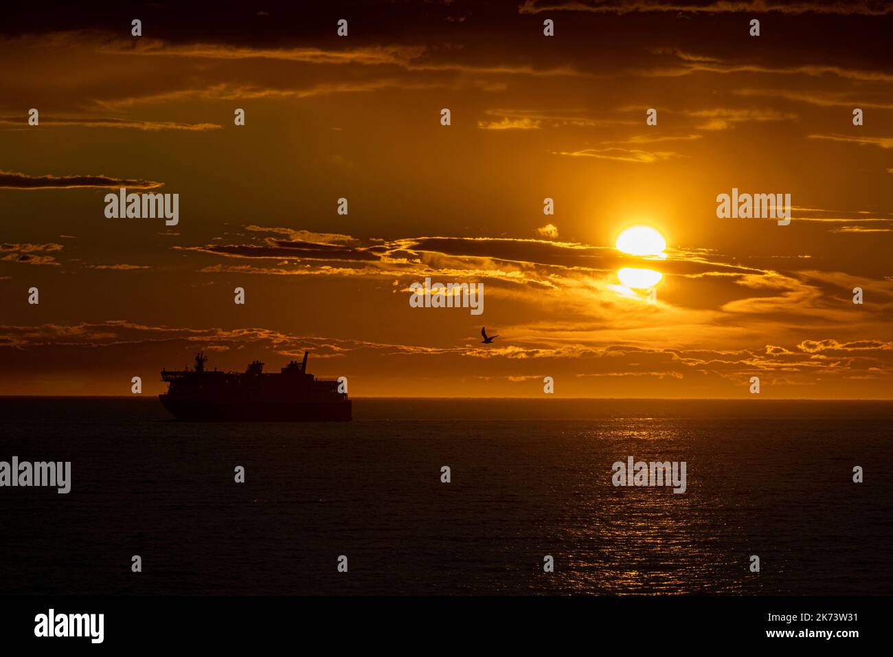 Un traghetto si avvicina a Matane, Quebec, mentre il sole tramonta il 25 luglio 2022. Foto Stock