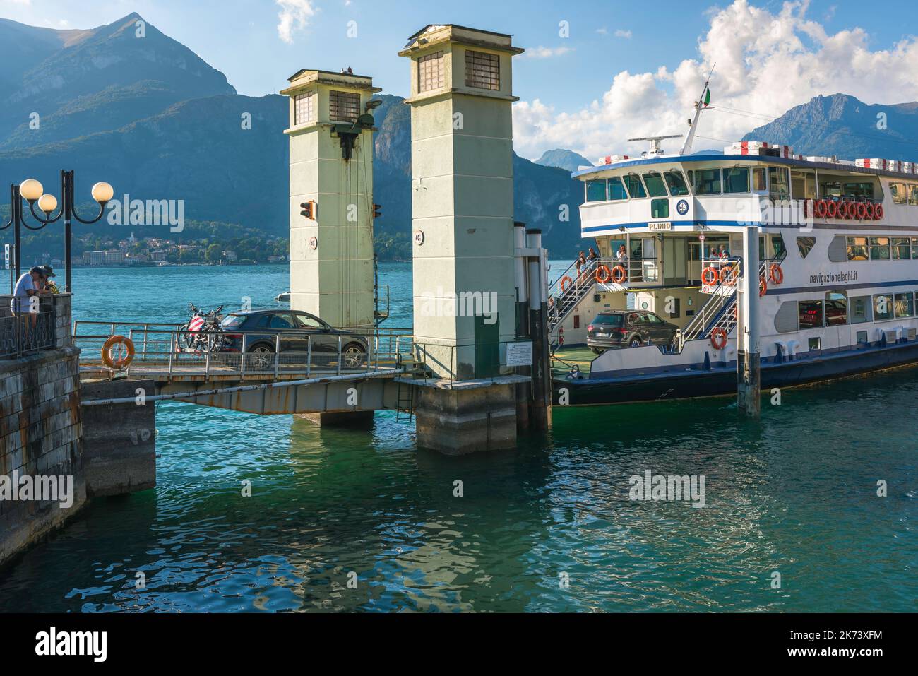 Car Ferry Lago di Como, vista in estate delle auto a bordo di un traghetto ormeggiato al molo nella pittoresca città di Bellagio, Italia Foto Stock