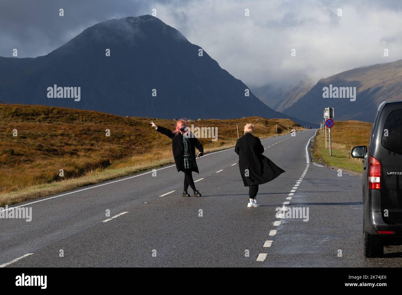 I turisti scattano foto nel mezzo della strada panoramica ma veloce e trafficata A82 attraverso Glencoe, Scozia, Regno Unito Foto Stock