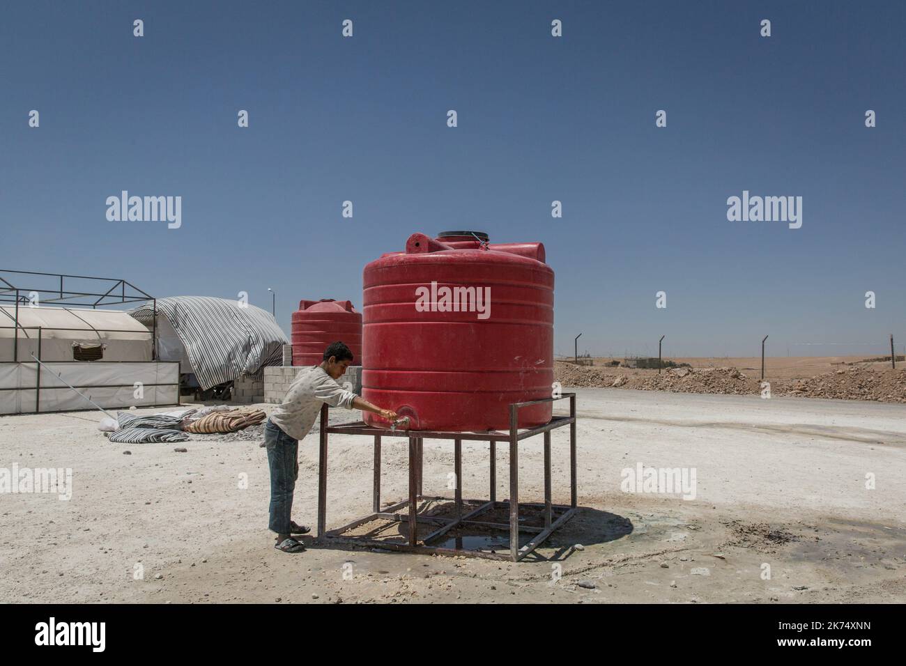 Juillet 2017 - Syrie - Rojava - Syrie du Nord - Camp de deplaces d'Ain Issa / Ambiance de camp / un jeune syrienn originaire de Raqqa vient de prendre de l'eau a la fontaine filtree ( au chlore) Chris Huby / le Pictorium - Siria: Campo profughi di Ain Issa - 08/07/2017 - Siria / Rojava / Raqqa - Foto Stock