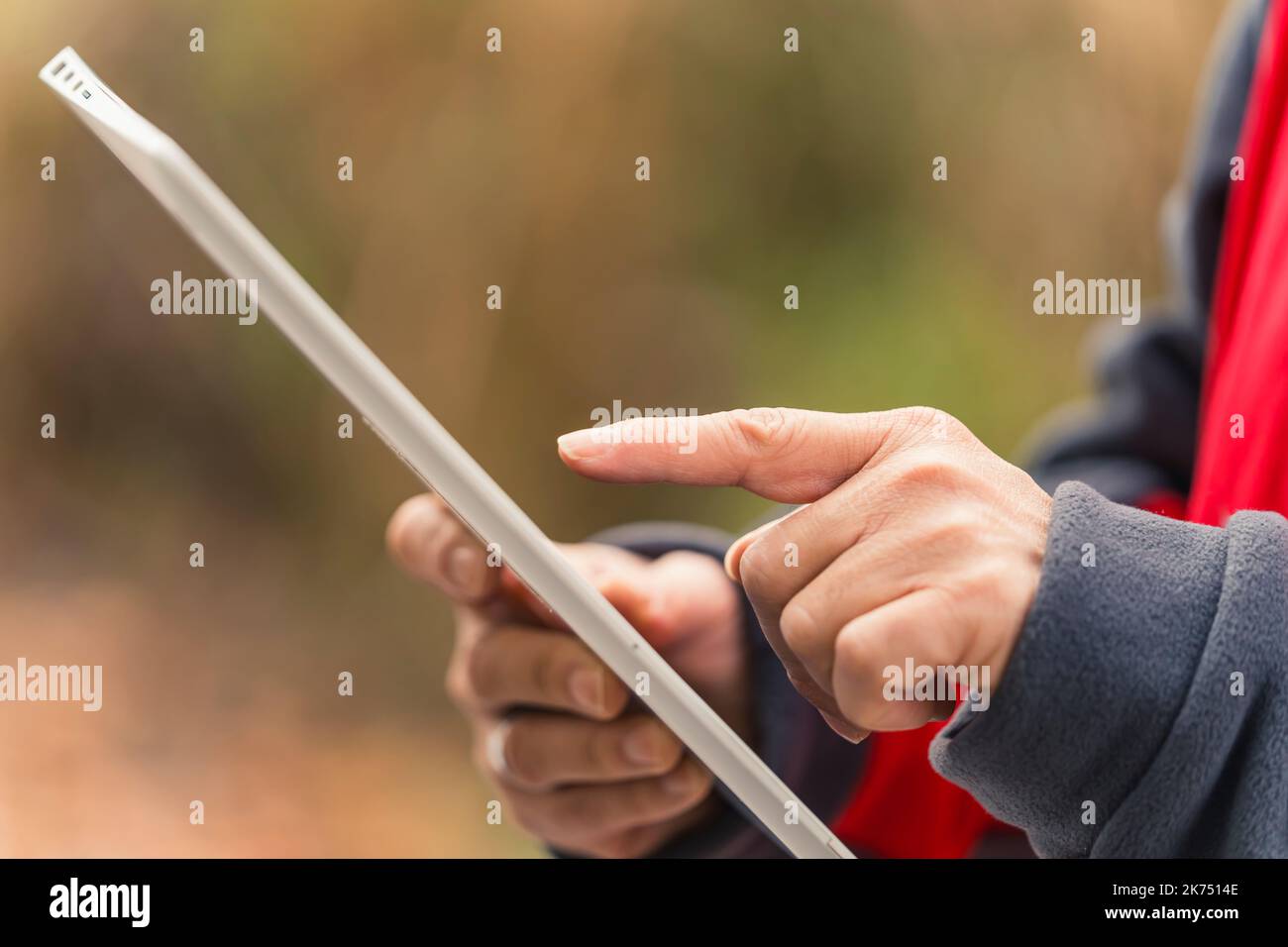 Primo piano delle mani di un uomo caucasico di mezza età, utilizzando un tablet elettronico per il lavoro, controllando le informazioni, scorrendo con un dito. Foto di alta qualità Foto Stock