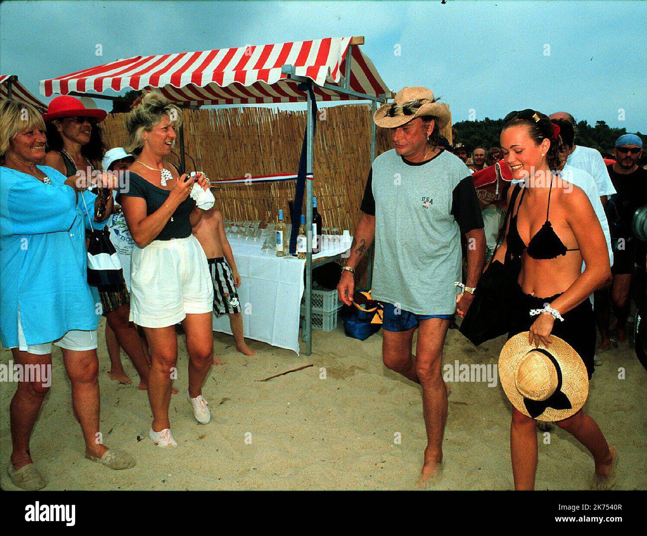 SAINT TROPEZ - HALLYDAY: 1995 AGOSTO JOHNNY HALLYDAY E LAETIA SULLA SPIAGGIA DI RAMATUELLE PER UN PICNIC ORGANIZZATO DA CHRISTOPHE LEROY FILES - JOHHNY HALLYDAY, Che è diventato il primo cantante gallico a divulgare rock n' roll in Francia e ha venduto oltre 110 milioni di dischi durante una carriera musicale che si estende per oltre mezzo secolo, è morto. Aveva 74 anni e combatteva il cancro per diversi mesi. Ampiamente conosciuto come il 'Elvis francese,' Hallyday ha iniziato la sua carriera cantando alla fine degli anni '1950s specializzandosi in versioni di copertina in lingua francese di famose canzoni di artisti come gene Vincent, Eddie Cochrane ed Elvis Pre Foto Stock