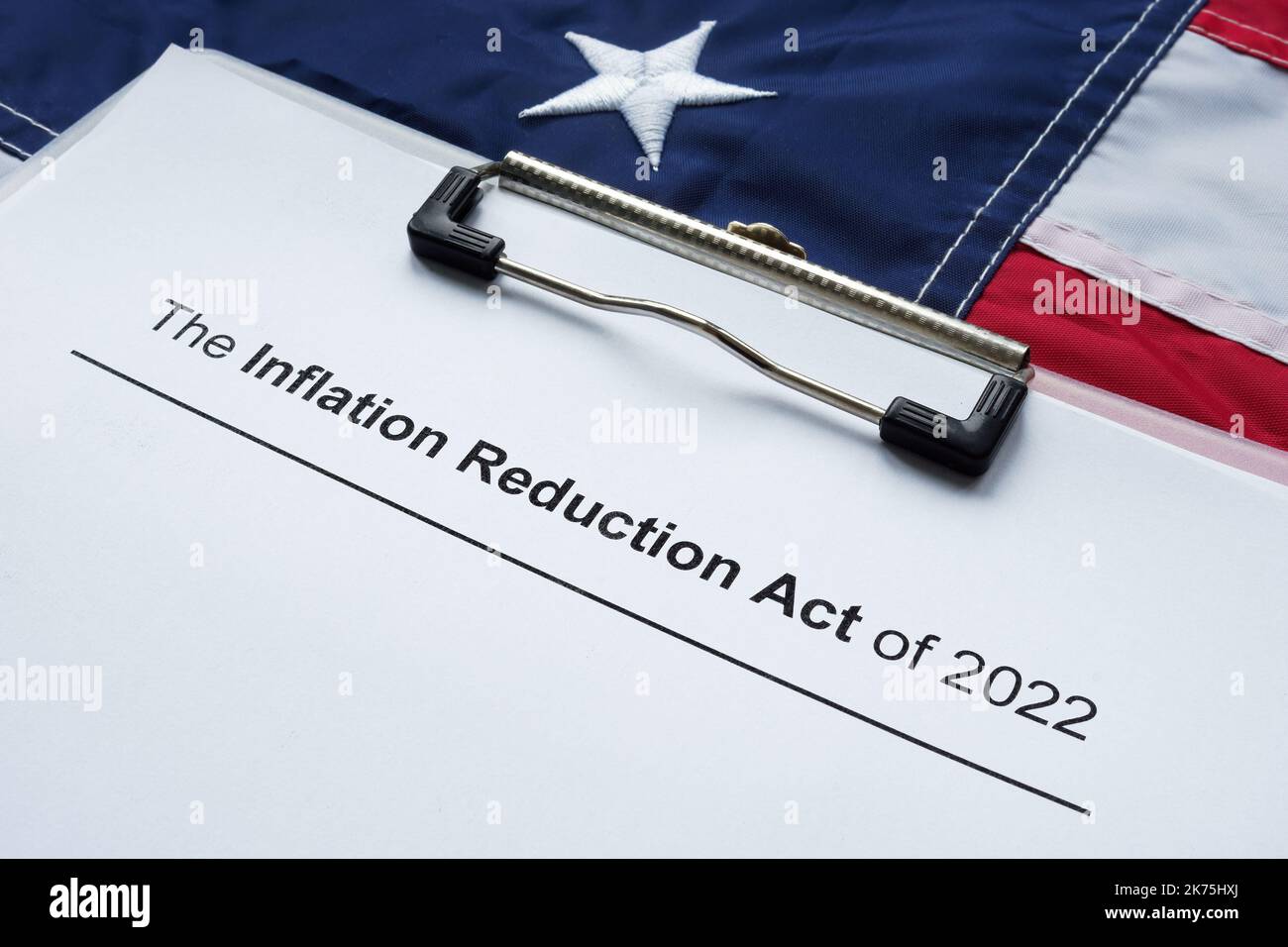 Documenti con l'atto di riduzione dell'inflazione di 2022 e bandiera. Foto Stock